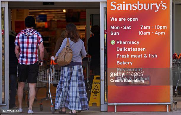 Customer pushes a shopping cart as she enters a Sainsbury's supermarket store, operated by J Sainsbury Plc, in Godalming, U.K., on Thursday, May 2,...