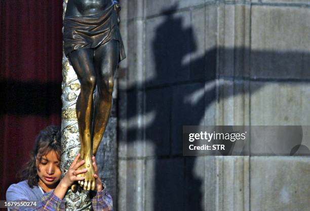 Guatemalan prays for Pope John Paul II holding the feet of the effigy of the Black Christ of Esquipulas, 02 April, 2005 at the Metropolitan Cathedral...