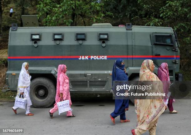 September 19 Srinagar Kashmir, India : Women walk past an armoured vehicle near the site of gun-battles between militants and security forces in...