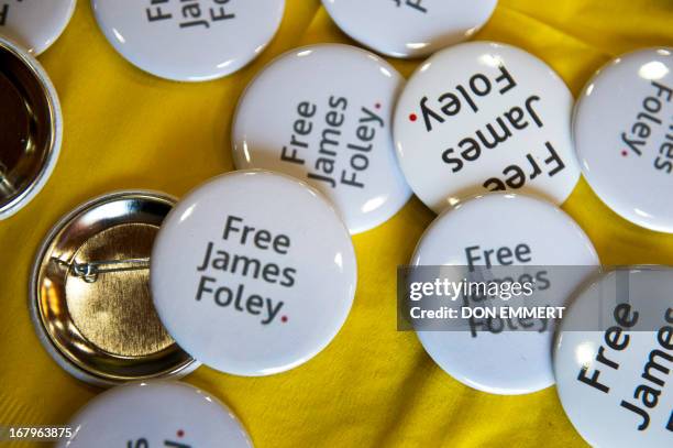 Buttons in support of James Foley are displayed during a panel discussion about the importance and dangers of reporting on world conflicts at a Free...