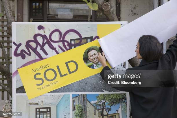 An agent puts up a sold sign at a house auction in Sydney, Australia, on Saturday, August 12, 2023. Photographer: Brent Lewin/Bloomberg via Getty...