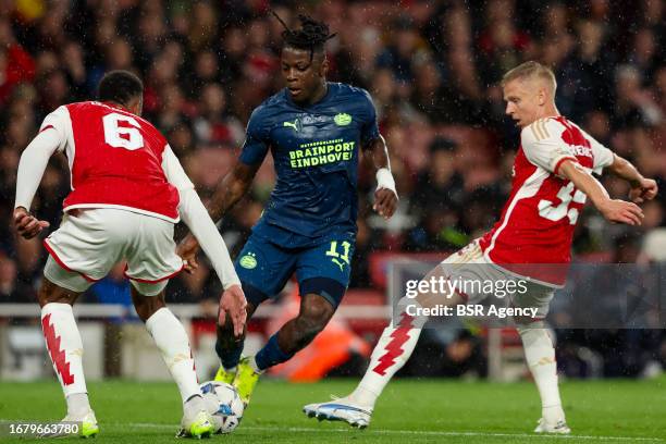 Johan Bakayoko of PSV is challenged by Gabriel of Arsenal, Oleksandr Zinchenko of Arsenal during the UEFA Champions League Group B match between...