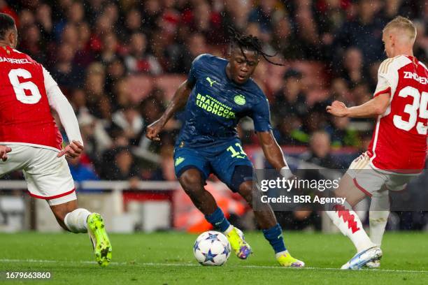 Johan Bakayoko of PSV is challenged by Gabriel of Arsenal, Oleksandr Zinchenko of Arsenal during the UEFA Champions League Group B match between...