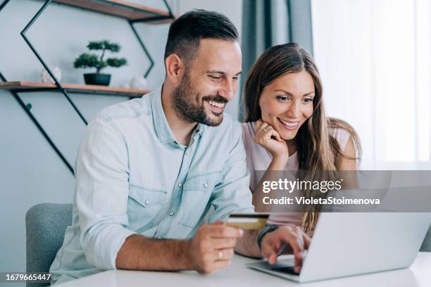 lovely couple using laptop for online shopping. - heteroseksueel koppel stockfoto's en -beelden
