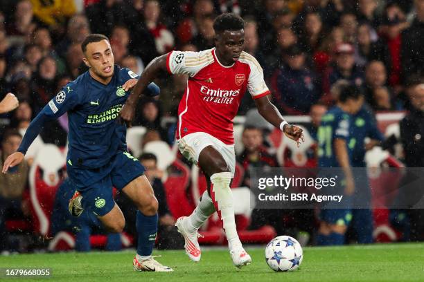 Bukayo Saka of Arsenal is challenged by Sergino Dest of PSV during the UEFA Champions League Group B match between Arsenal and PSV at Emirates...