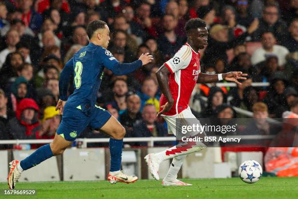 Bukayo Saka of Arsenal is challenged by Sergino Dest of PSV during the UEFA Champions League Group B match between Arsenal and PSV at Emirates...