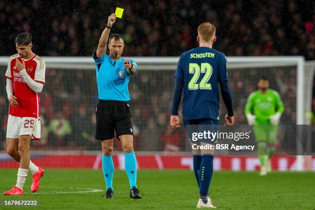 Referee Felix Zwayer shows the yellow card to Jerdy Schouten of PSV during the UEFA Champions League Group B match between Arsenal and PSV at...