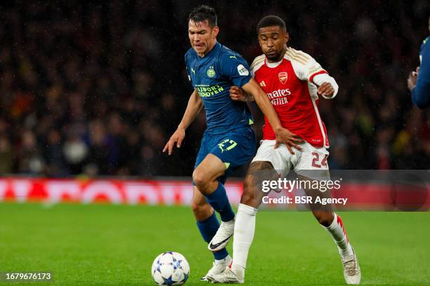 Reiss Nelson of Arsenal is challenged by Hirving Lozano of PSV, Jordan Teze of PSV during the UEFA Champions League Group B match between Arsenal and...