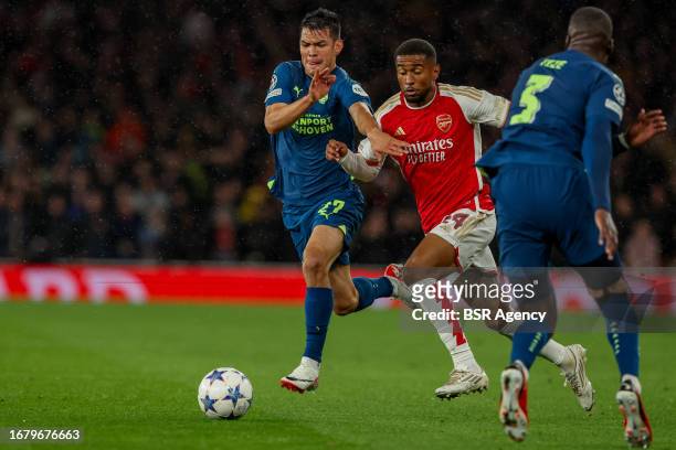 Reiss Nelson of Arsenal is challenged by Hirving Lozano of PSV, Jordan Teze of PSV during the UEFA Champions League Group B match between Arsenal and...