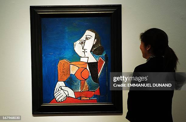 "Femme assise en costume rouge sur fond bleu" by Pablo Picasso is on display during a preview of Christie's Impressionist and Modern Art sales in New...