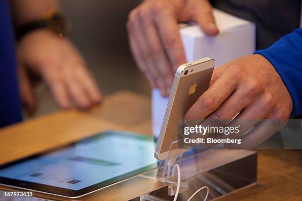 An Apple Inc. IPhone 5 is seen on display at the new Apple Inc. Store located on Kurfurstendamm Street in Berlin, Germany, on Friday, May 3, 2013....