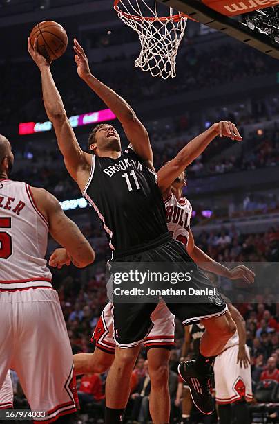 Brook Lopez of the Brooklyn Nets shoots between Carlos Boozer and Joakim Noah of the Chicago Bulls in Game Six of the Eastern Conference...