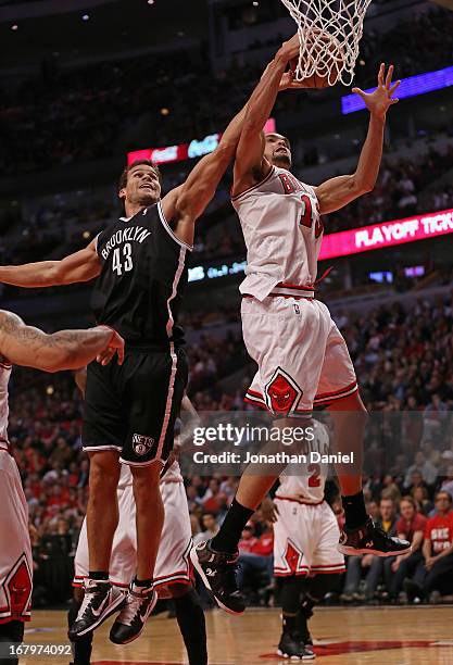 Joakim Noah of the Chicago Bulls rebounds over Kris Humphries of the Brooklyn Nets in Game Six of the Eastern Conference Quarterfinals during the...