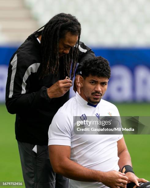 Tana Umaga assistant coach of Samoa helps Theo McFarland of Samoa with the GPS prior to their captains run ahead of their Rugby World Cup France 2023...