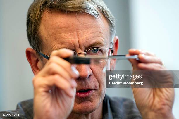 John Doerr, a senior partner with Kleiner Perkins Caufield & Byers, holds a pair of Google Inc. Glass internet glasses as he speaks during an...