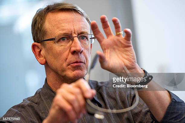 John Doerr, a senior partner with Kleiner Perkins Caufield & Byers, holds a pair of Google Inc. Glass internet glasses as he speaks during an...