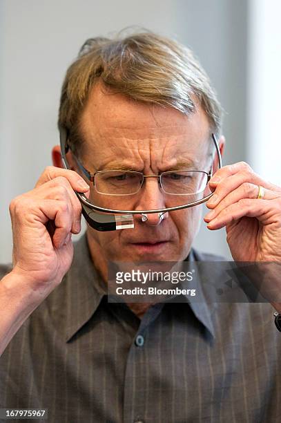 John Doerr, a senior partner with Kleiner Perkins Caufield & Byers, holds a pair of Google Inc. Glass internet glasses as he speaks during an...