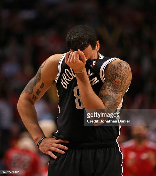 Deron Williams of the Brooklyn Nets wipes his face after being hit in the eye against the Chicago Bulls in Game Six of the Eastern Conference...