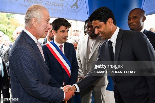 Paris Saint Germain's Qatari president Nasser al-Khelaifi greets Britain's King Charles III, next to Mayor of Saint-Denis Mathieu Hanotin and Ivorian...