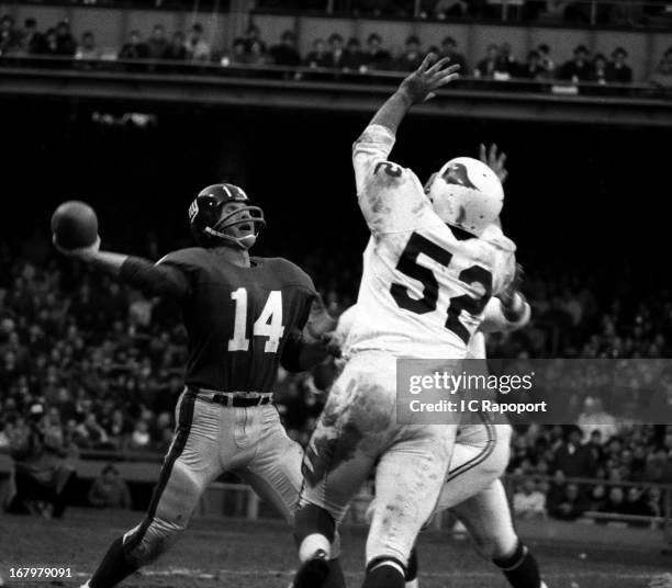 Marion Rushing of the St. Louis Cardinals moves in on Giants quarterback, Y.A. Tittle as he throws a touchdown pass in Yankee Stadium on November 24,...