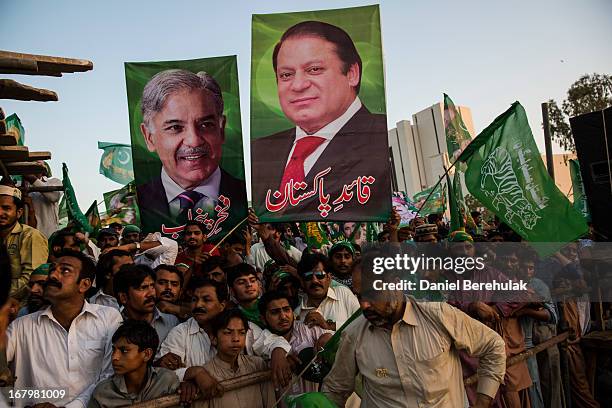 Supporters hold placards of Nawaz Sharif and his brother Shahbaz Sharif , leaders of political party Pakistan Muslim League-N , during an election...