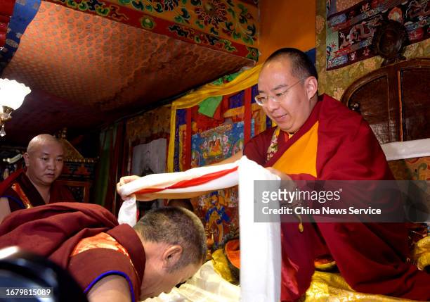 The 11th Panchen Lama Bainqen Erdini Qoigyijabu presents a khata to a Tibetan monk at the Tashilhunpo Monastery, the traditional seat of the Panchen...