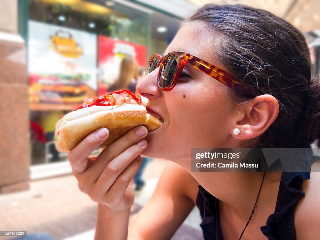 Girl eating a hotdog in chile