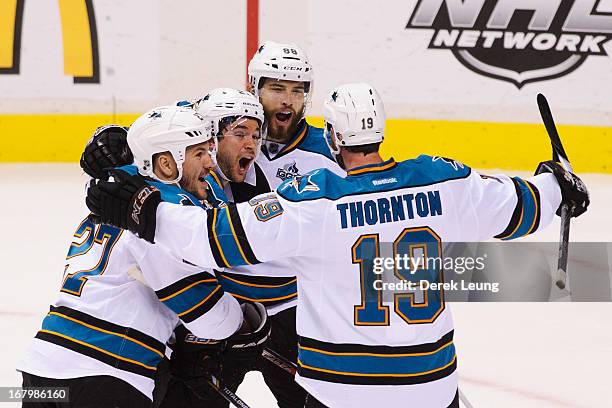 Joe Thornton of the San Jose Sharks celebrates his first-period goal against the Vancouver Canucks with teammates Scott Hannan, T.J. Galiardi, and...