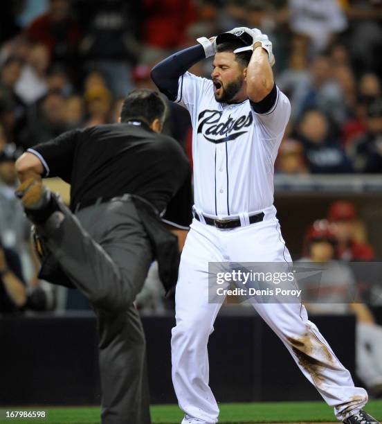 Yonder Alonso of the San Diego Padres reacts after being called out at the plate by umpire Mike DiMuro in the fourth inning of a baseball game...