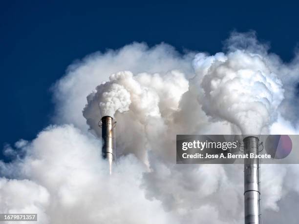 industrial factory chimney emitting smoke and gas pollution into the atmosphere. - climate change global warming stock pictures, royalty-free photos & images