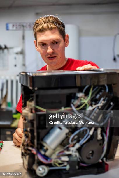 capable technician determined to identify reason for coffee machine malfunction scrutinizing inner workings - electric motor disassembled stock pictures, royalty-free photos & images