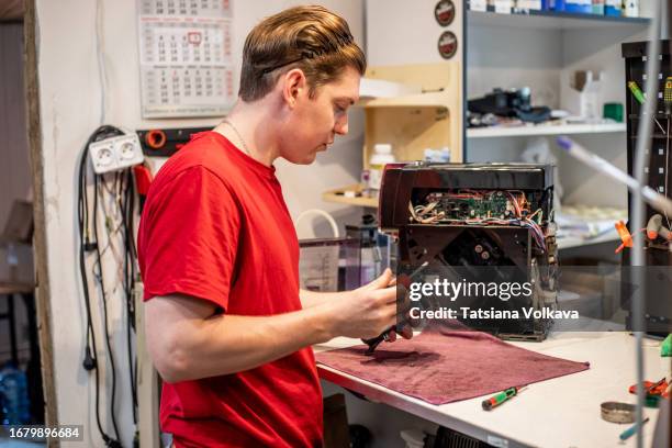 talented technician carefully removes screws from coffee machine brewing unit under bright light of service center - appliance repair stock pictures, royalty-free photos & images