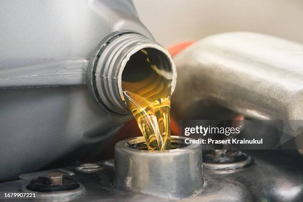 engineer add motor oil into the engine - lubricación fotografías e imágenes de stock