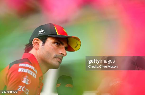 Carlos Sainz of Spain and Ferrari talks to the media in the Paddock during previews ahead of the F1 Grand Prix of Singapore at Marina Bay Street...