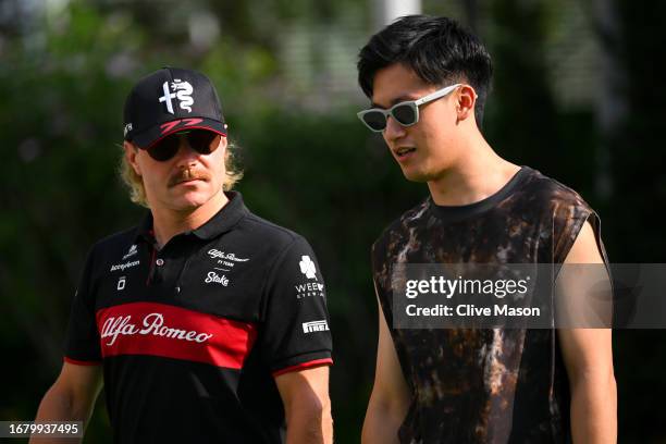 Valtteri Bottas of Finland and Alfa Romeo F1 and Zhou Guanyu of China and Alfa Romeo F1 walk in the Paddock during previews ahead of the F1 Grand...