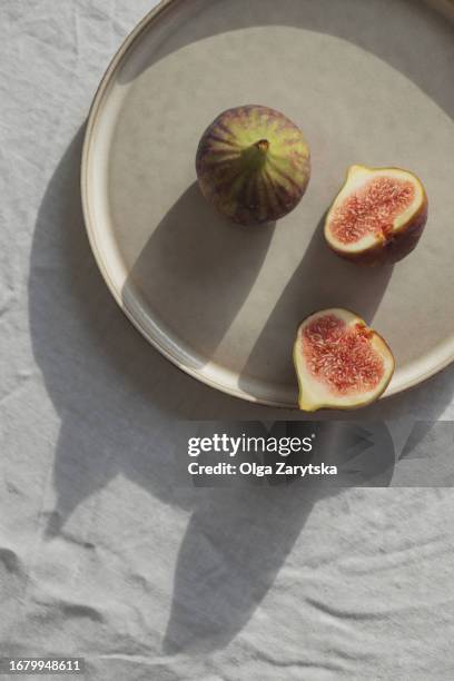 figs on plate in sunlight. - purple figs stock pictures, royalty-free photos & images