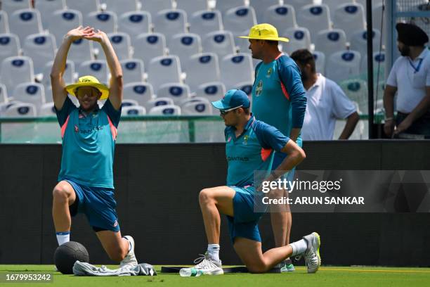 Australia's Josh Hazlewood stretches during a practice session at Punjab Cricket Association IS Bindra Stadium in Mohali on September 21 on the eve...