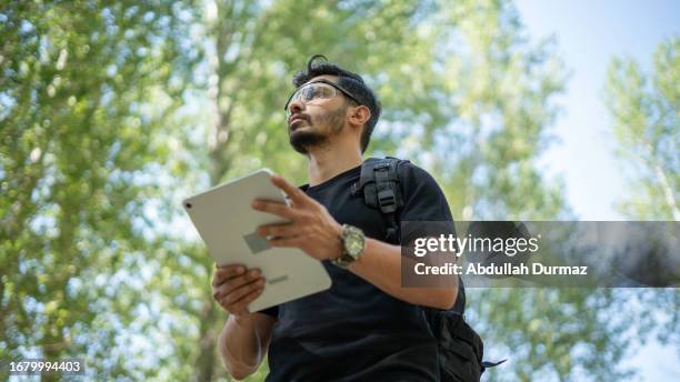 researcher man doing environmental research with digital tablet in forest - forestry worker stock pictures, royalty-free photos & images