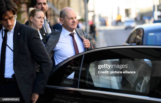 September 2023, Berlin: German Chancellor Olaf Scholz climbs into an armored limousine, accompanied by bodyguards from the Federal Criminal Police...