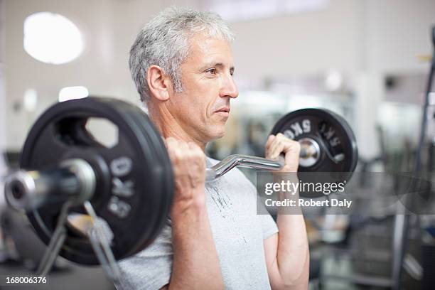 portrait of smiling man holding barbell in gymnasium - fitness man gym stockfoto's en -beelden