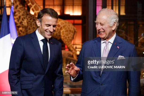 French President Emmanuel Macron and Britain's King Charles III laugh during their visit to the Museum of Natural History to meet business leaders...