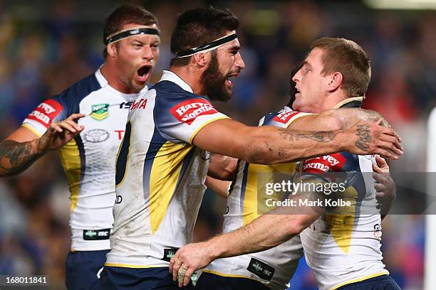 Ashton Sims and James Tamou of the Cowboys congratulate Brent Tate of the Cowboys after he scored a try during the round eight NRL match between the...