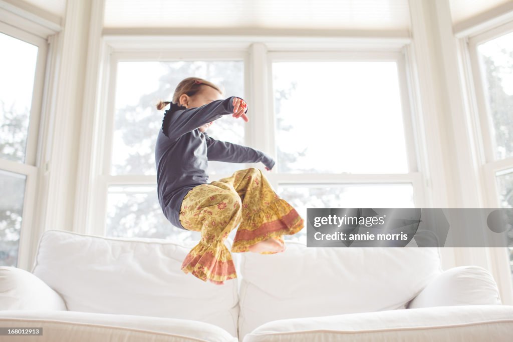 Girl jumping on couch