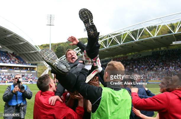 Barnsley manager David Flitcroft is thrown into the air by his players as they celebrate survival at the end of the npower Championship match between...