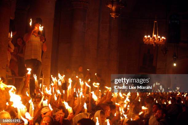 Christian worshipers light candles lit from a flame that emerged from the tomb believed to be of Jesus Christ as they take part in the ceremony of...