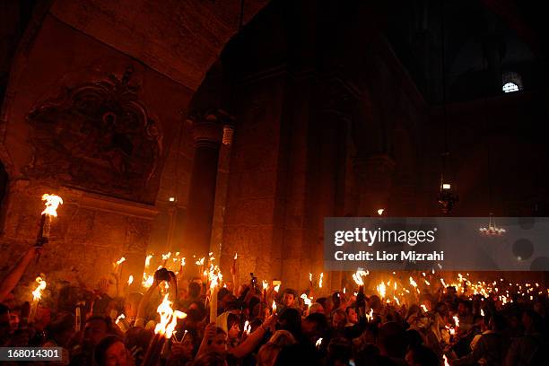 Christian worshipers light candles lit from a flame that emerged from the tomb believed to be of Jesus Christ as they take part in the ceremony of...