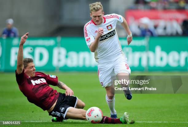 Mike Frantz of Nuernberg challenges Andre Schuerrle of Leverkusen during the Bundesliga match between 1. FC Nuernberg and Bayer 04 Leverkusen at...