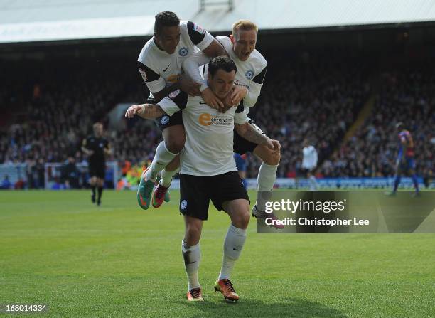 Lee Tomlin of Peterborough is jumped on by Nathaniel Mendez-Laing and Alex Pritchard as they celebrate scoring their first goal during the npower...