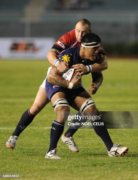 Rugby player Christopher Hitch of Philippines is tackled by Hong Kong rugby player Peter Mckee during their Rugby Asian Five-Nations match at the...