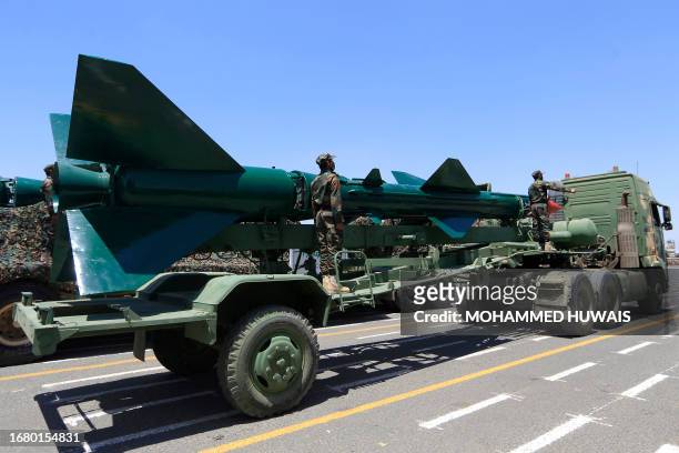 Huthi soldiers stand guard on a missile carrier during an official military parade marking the ninth anniversary of the Huthi takeover of the...